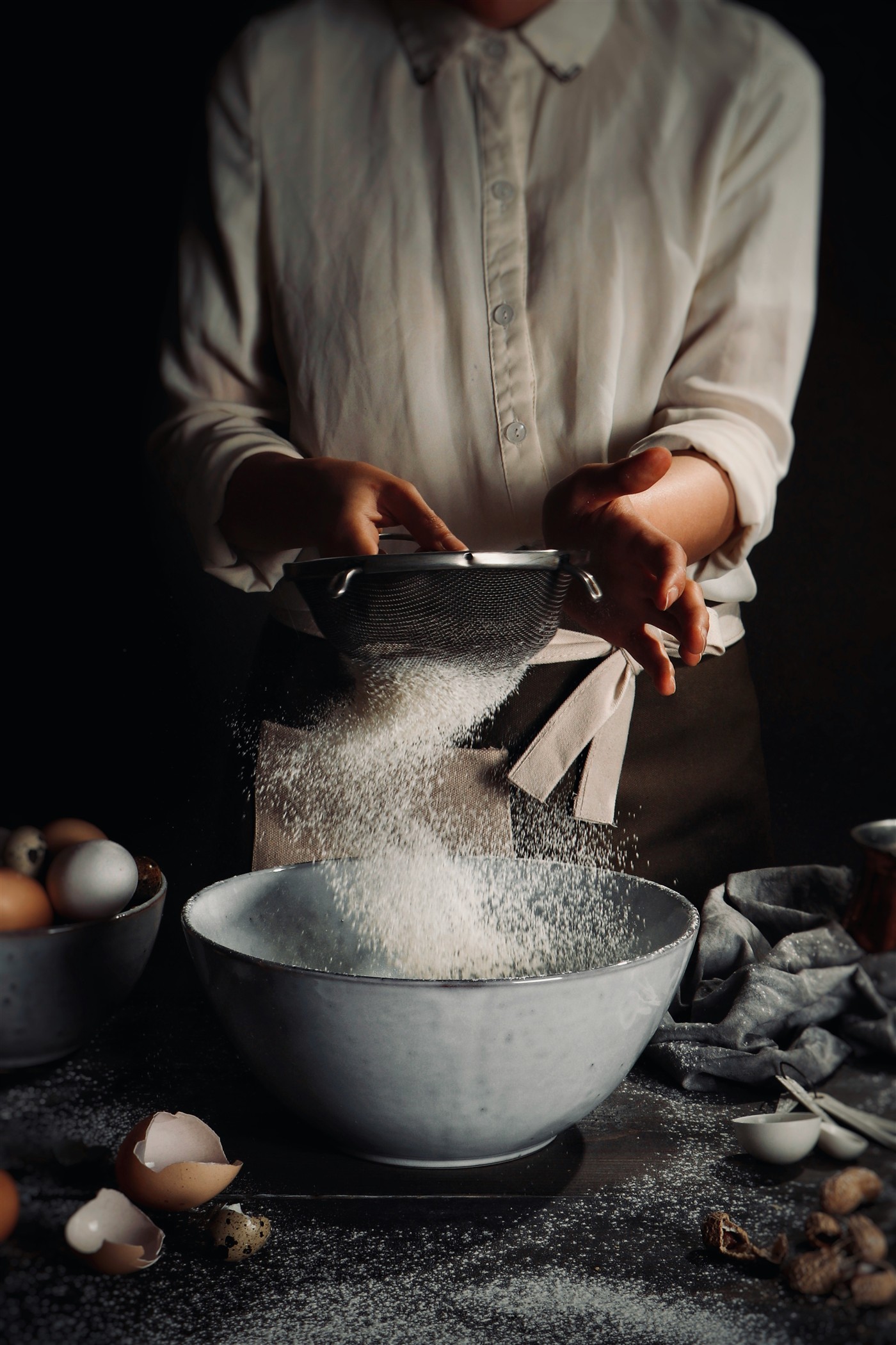 Baker sifting flour
